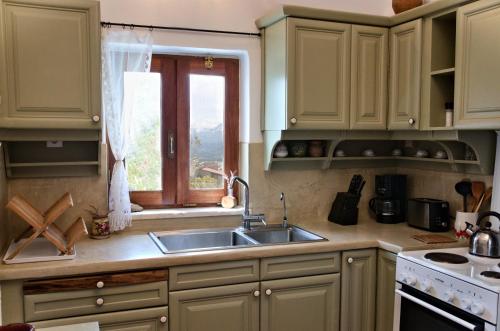 a kitchen with a sink and a window at Villa Athina in Megála Khoráfia
