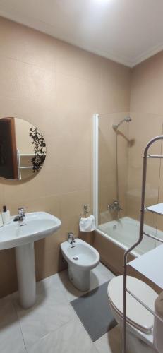 uma casa de banho com um lavatório, um WC e uma banheira em Piso turístico Dena em Pontevedra