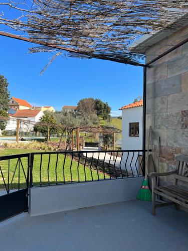 a balcony with a bench and a view of a yard at Casa Bizarra in Castanheira de Pêra