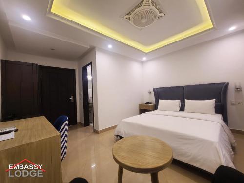 a bedroom with a large bed and a table at Embassy Lodge in Islamabad