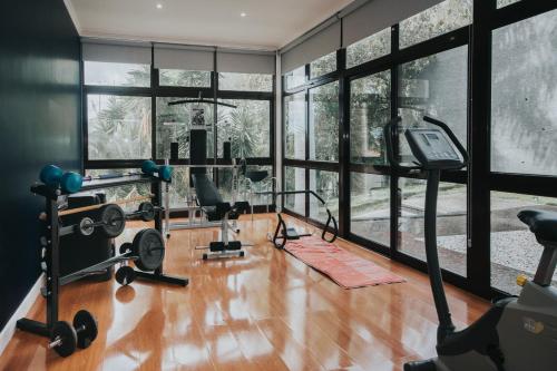 a gym with gym equipment and large windows at Vila Crerital - By Wehost in São Gonçalo