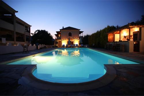 a swimming pool at night with a building in the background at Sun Accommodation in Skopelos Town