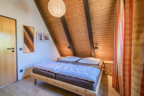 ein Schlafzimmer mit einem Bett in einem Holzzimmer in der Unterkunft Ferienwohnpark Immenstaad am Bodensee Nurdachhaus Typ 8 NDT 036 in Immenstaad am Bodensee