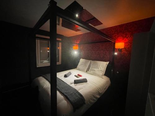 a bedroom with a canopy bed with two books on it at Atypaluxe in Épinal