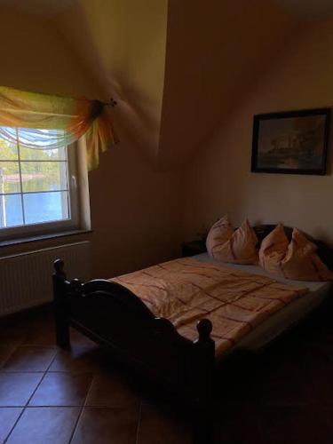 a bedroom with a bed and a window at Dom Pod Dębem in Majdy