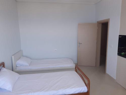 2 camas en una habitación con paredes blancas en Angels apartment, en Lukovë