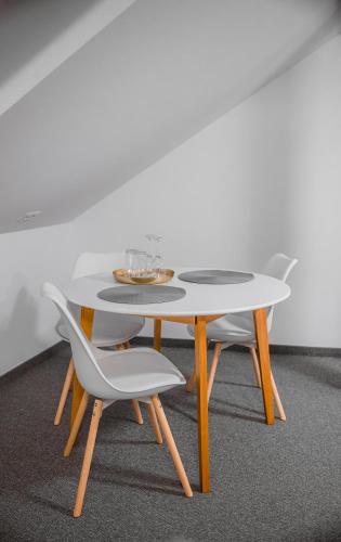 a white table with two chairs and a table with glasses on it at The Dom 21 in Cluj-Napoca