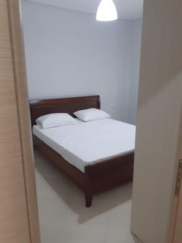 - un lit avec des draps et des oreillers blancs dans l'établissement Angels apartment, à Lukovë