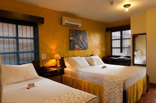 una camera d'albergo con due letti e uno specchio di Hostal San Francisco a San Cristóbal