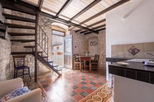 モーディカにあるSI-Moutique Le Case degli Avi barocche, con terrazza panoramicaのキッチン、ダイニングルーム(階段、テーブル付)