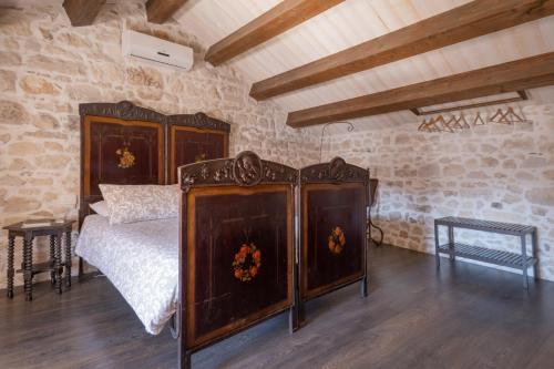 a bedroom with a bed and a stone wall at SI-Moutique Le Case degli Avi barocche, con terrazza panoramica in Modica