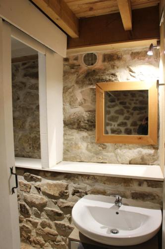 uma casa de banho com um lavatório e uma parede de pedra em Hameau Bechetoile em Burdignes