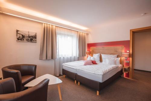 um quarto de hotel com uma cama e uma cadeira em Chalet Alpenstern em Oberstdorf