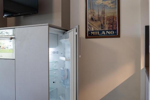 a refrigerator in a kitchen with a picture on the wall at APPARTAMENTO MACIACHINI, ZONA ISOLA in Milan