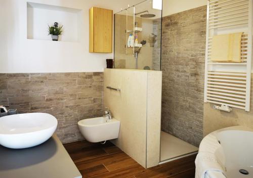 une salle de bain avec un lavabo, des toilettes et une douche dans l'établissement Casa Rustica con giardino, à Caprino Veronese
