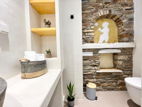 un camino in pietra in bagno con lavandino di Nikiforos Boutique apartment a Naxos Chora