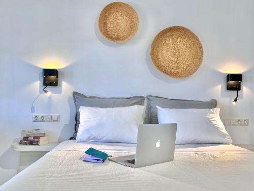 a laptop computer sitting on top of a bed at Nikiforos Boutique apartment in Naxos Chora