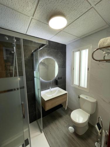 a bathroom with a toilet and a sink and a shower at Hostal Calderón de la Barca in Zalamea de la Serena