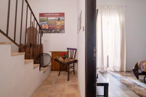 a hallway with a staircase and a table and a chair at SI-Moutique Le Case degli Avi barocche, con terrazza panoramica in Modica