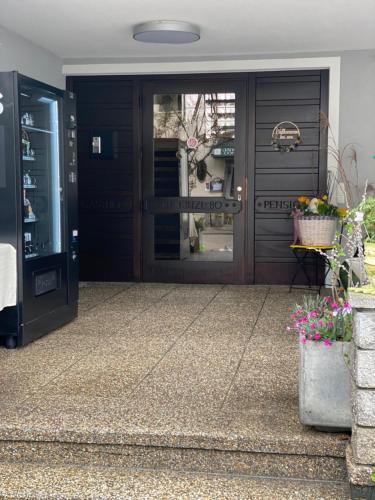 a front door of a house with flowers in front of it at Pension Kinzl mit E-Ladestation in Offenhausen