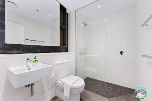 a white bathroom with a toilet and a sink at Aircabin - Chatswood - Walk to station - 2 Beds Apt in Sydney