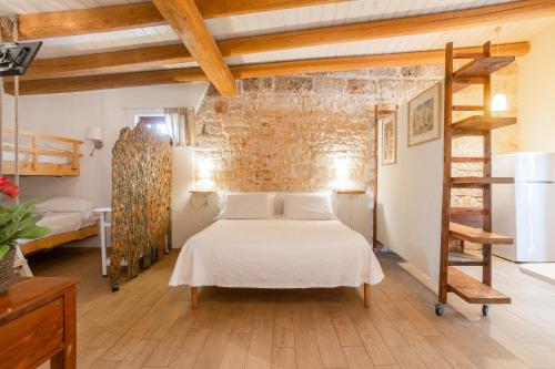 a bedroom with a bed and a brick wall at Casina dei Preti in Conversano