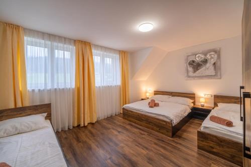 um quarto com 2 camas e uma grande janela em Apartmány na Bukovce - GG em Cervena Voda
