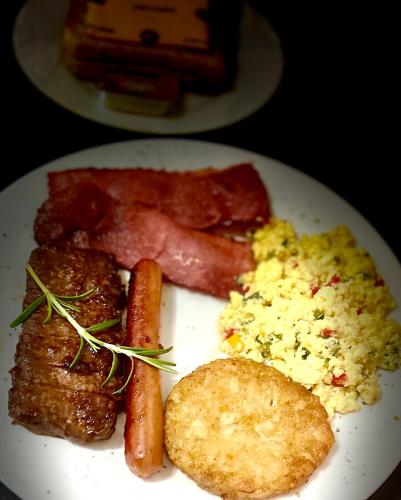 a plate of breakfast food with sausage and eggs at Swane’s guesthouse in Rustenburg