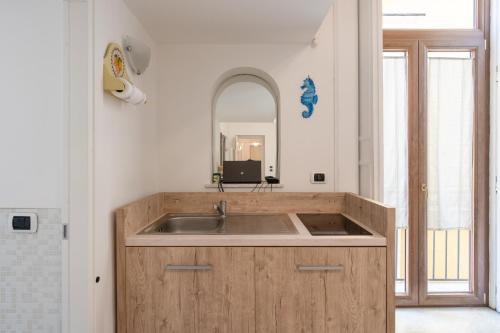 - une cuisine avec un évier et un miroir dans l'établissement The Charming Suites, à Sorrente
