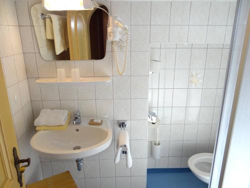 La salle de bains est pourvue d'un lavabo, d'un miroir et de toilettes. dans l'établissement Gästehaus Christl, à Radstadt