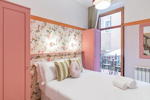 a bedroom with a white bed with a floral wall at Hotel Espana - Gruppo BLAM HOTELS in Rome