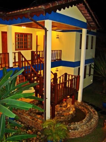 a house with a gazebo and a fire place at Pousada Só Natureza in Abraão