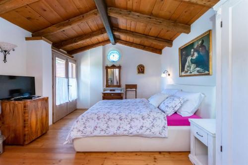 Un dormitorio con una cama grande y un televisor. en House Rada i Stanisav, en Mošćenička Draga
