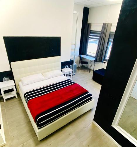a bedroom with a bed with a red blanket at HOTEL TECH in Brembate