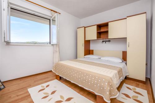 sypialnia z łóżkiem i dużym oknem w obiekcie Apartments Mirta w mieście Ražanj