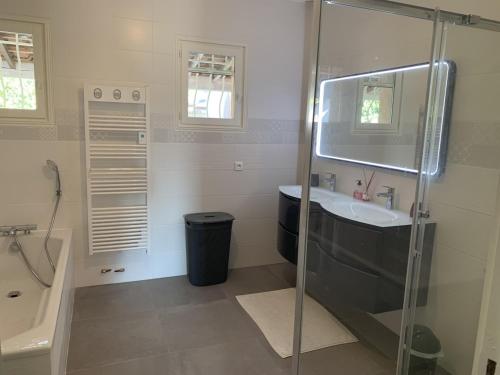uma casa de banho com uma cabina de duche em vidro e um lavatório. em Les Palmiers em Le Muy