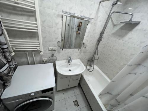 Baño blanco con lavabo y bañera en Hanrapetutyan Apartment, en Ereván