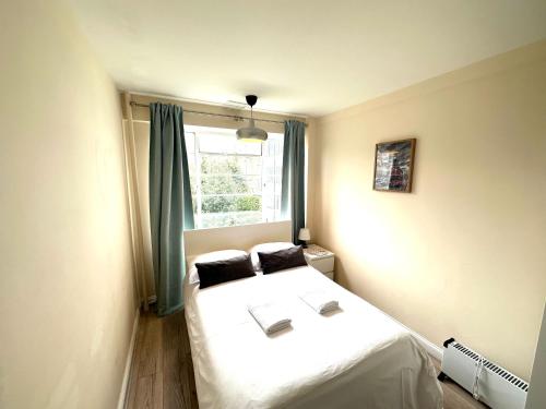 una camera con un letto bianco e una finestra di Camden Royale Apart a Londra