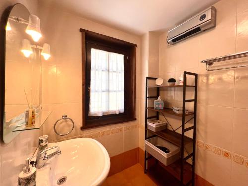 baño con lavabo, espejo y ventana en Apartament Les 3 Valls en Llavorsí