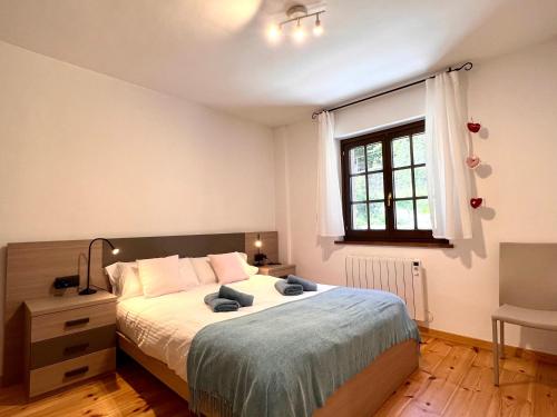 um quarto com uma cama grande e uma janela em Apartament Les 3 Valls em Llavorsí