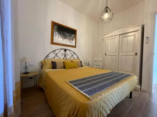 una camera da letto con un grande letto con copriletto giallo di Mareblu Simius a Villasimius