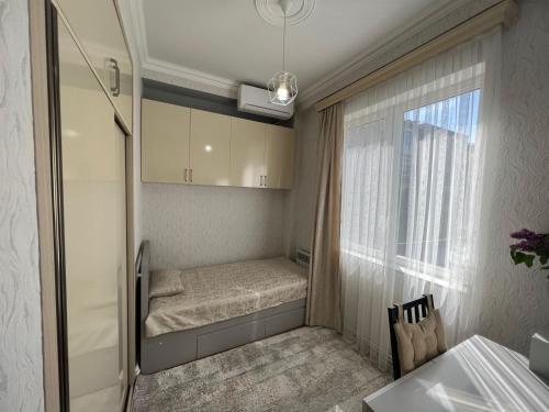 Habitación pequeña con cama y ventana en Hanrapetutyan Apartment, en Ereván