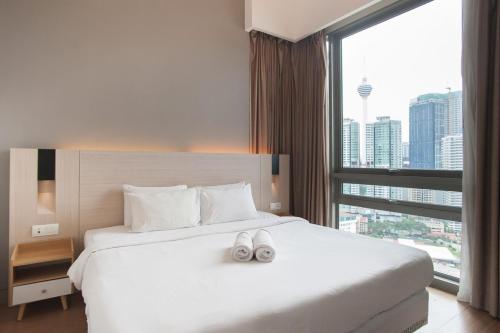 a hotel room with a bed with two shoes on it at Swiss Garden Residence Bukit Bintang in Kuala Lumpur