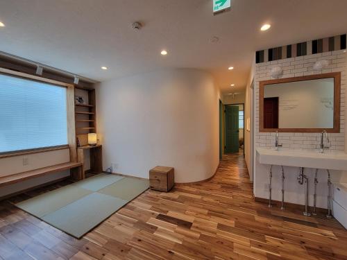 泊まる寿司屋一力 Sushi house في Itoshima: حمام مع حوض ونافذة كبيرة