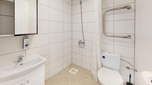 La salle de bains blanche est pourvue de toilettes et d'un lavabo. dans l'établissement Kivi Apartments, à Jõhvi