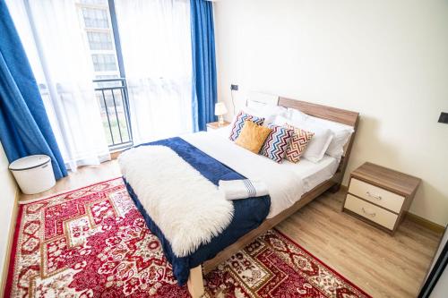 een slaapkamer met een bed en een groot raam bij Kingara Road Apartment in Nairobi