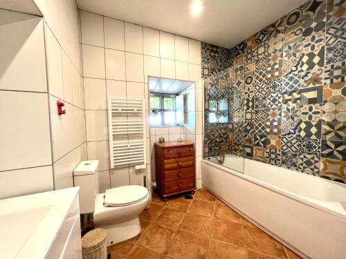 a bathroom with a toilet and a tub and a sink at Villa - Pequeno Paraíso, São Brás de Alportel in São Brás de Alportel