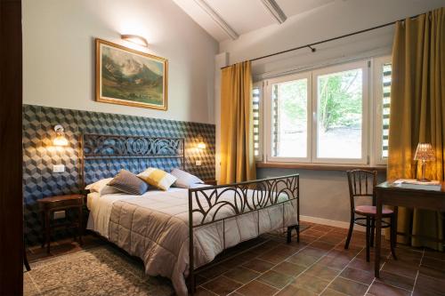 a bedroom with a bed and a desk and a window at La Giribaldina Winery & Farmhouse in Calamandrana