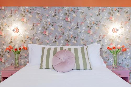 a bedroom with a white bed with a flowery wallpaper at Hotel Espana - Gruppo BLAM HOTELS in Rome