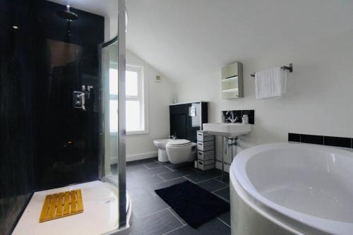 a bathroom with a tub and a toilet and a sink at Remarkable 3-Bed House in Bath in Bath
